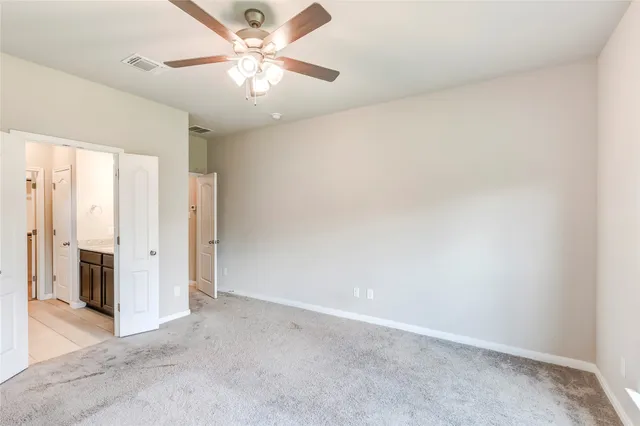 an empty room with a ceiling fan and a window
