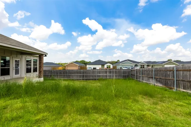 a view of a house with a big yard and potted plants