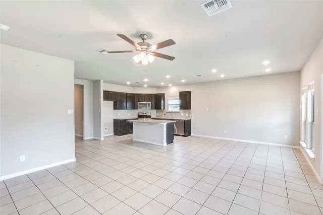 a view of kitchen with granite countertop cabinets and window