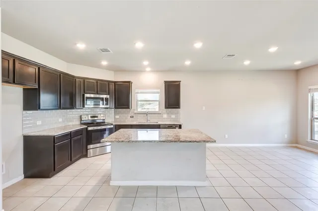 a large kitchen with stainless steel appliances lots of counter space and wooden floor