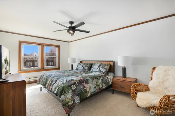 a bedroom with a bed couches and large window