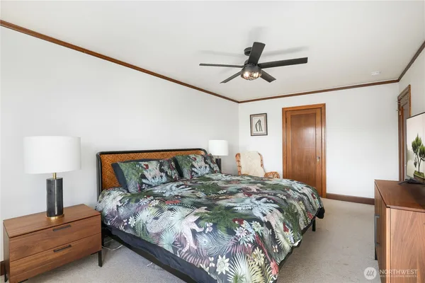 a bedroom with a bed and a lamp on the dresser