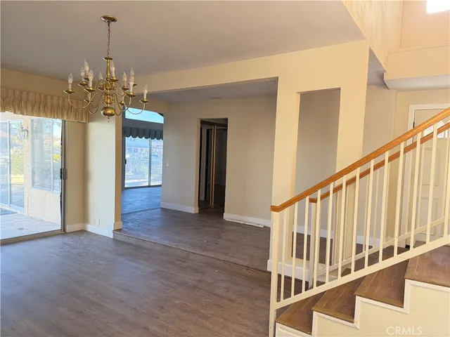 a view of a hallway with wooden floor and stairs