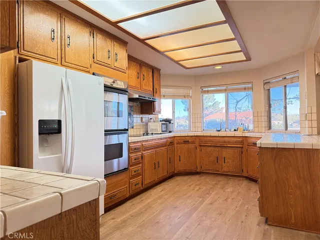 a kitchen with stainless steel appliances granite countertop a sink a stove and refrigerator