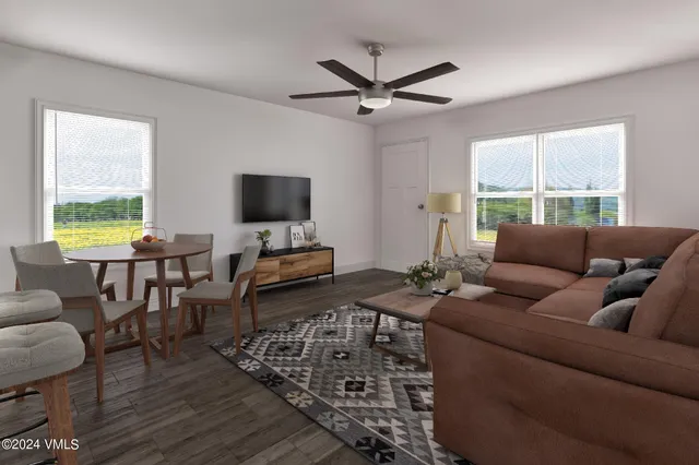 a living room with furniture a window and a flat screen tv