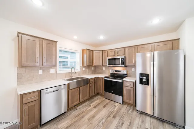 a kitchen with stainless steel appliances granite countertop a refrigerator and a stove top oven