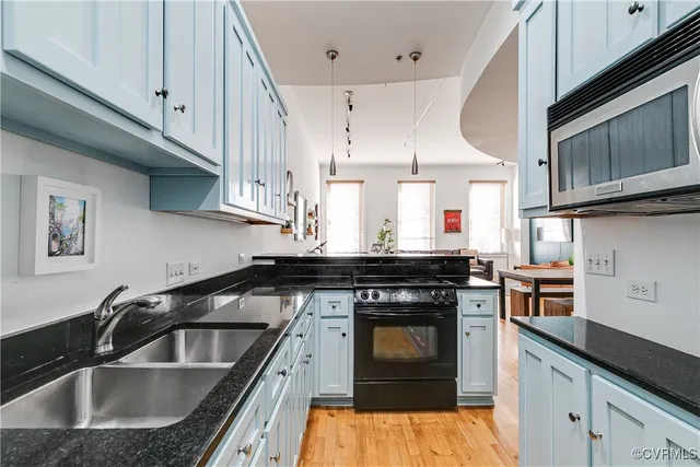 a kitchen with stainless steel appliances granite countertop a sink stove and cabinets