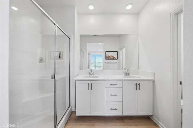 a bathroom with a double vanity sink a mirror and a bathtub