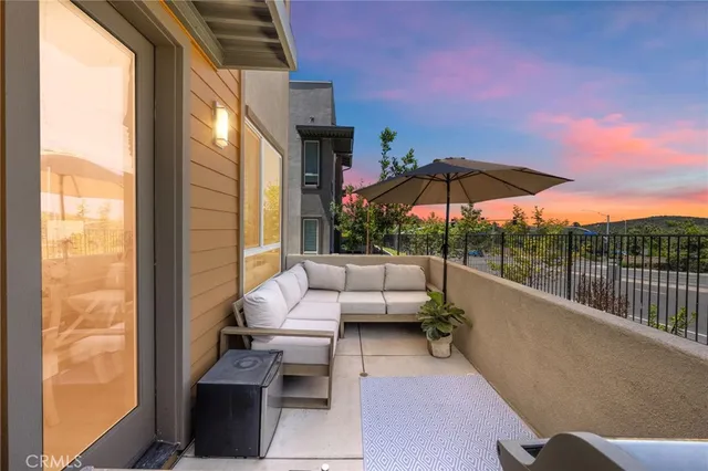 a view of balcony with couches and umbrella