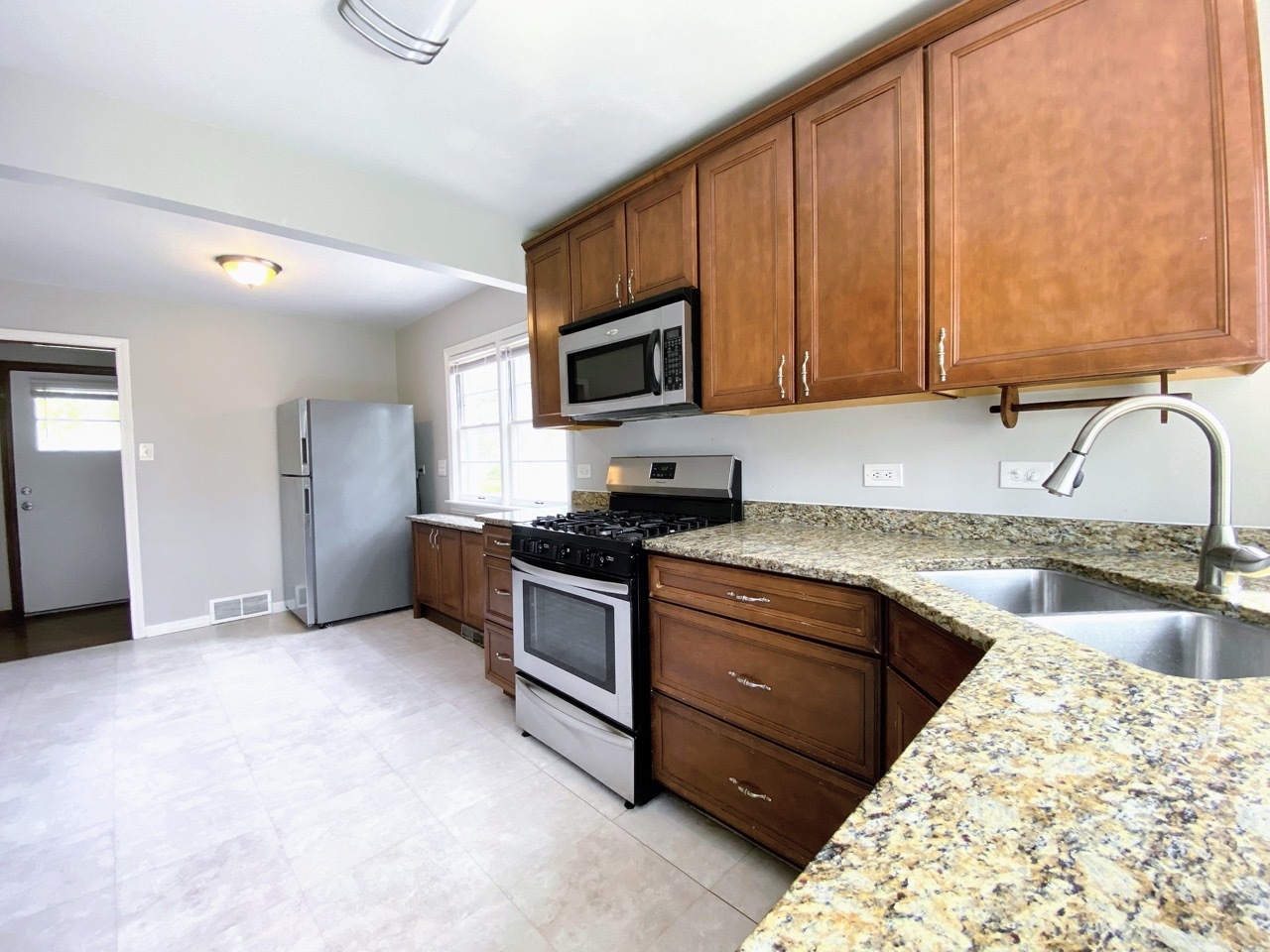 3003 Longfellow Avenue Hazel Crest, IL 60429 - Photo 4 of 19 a kitchen with granite countertop wooden cabinets stainless steel appliances and a sink