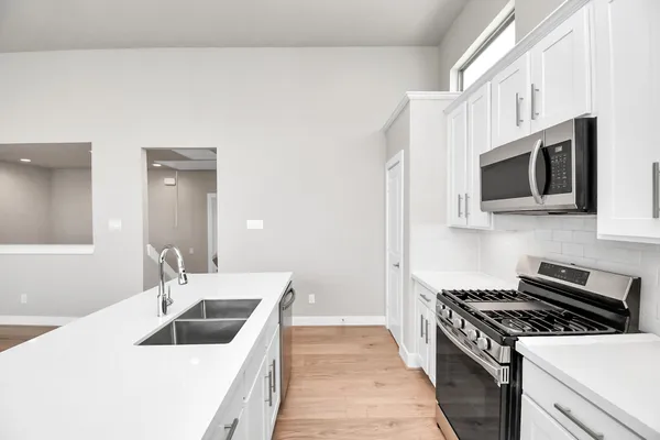 a kitchen with a stove a sink and a window
