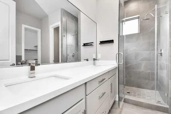a bathroom with a shower sink and mirror