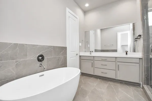 a bathroom with a tub sink and mirror