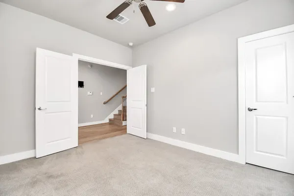 an empty room with ceiling fan and window