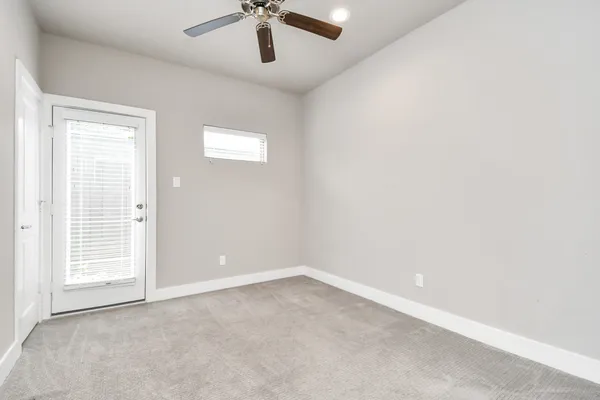 an empty room with a window and a ceiling fan