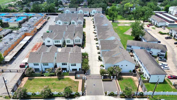 an aerial view of a house with a garden and lake view