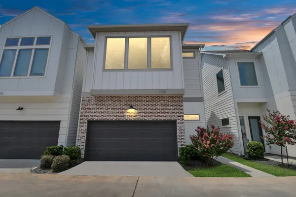 a front view of a house with plants