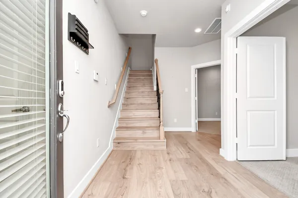 a view of a hallway with wooden floor and staircase