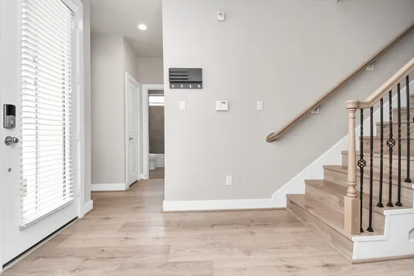 a view of entryway and hall with wooden floor