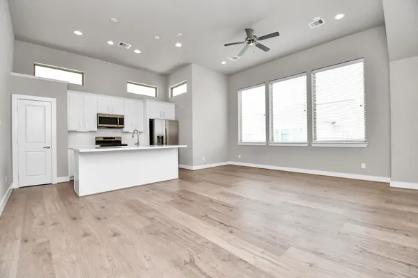 a view of a kitchen with a sink stove cabinets and empty room