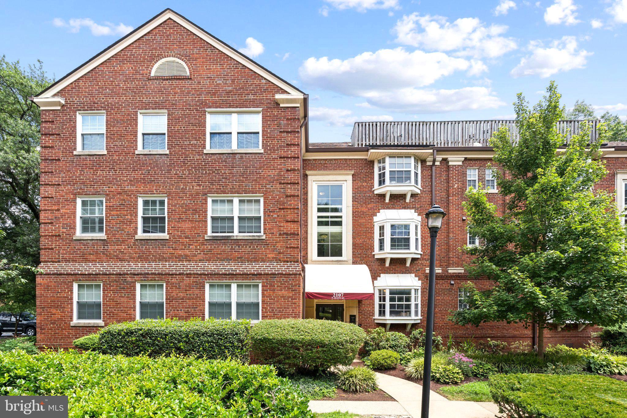 2107 North Scott Street, Unit 70 Arlington, VA 22209 - Photo 1 of 19 a front view of a house with a yard