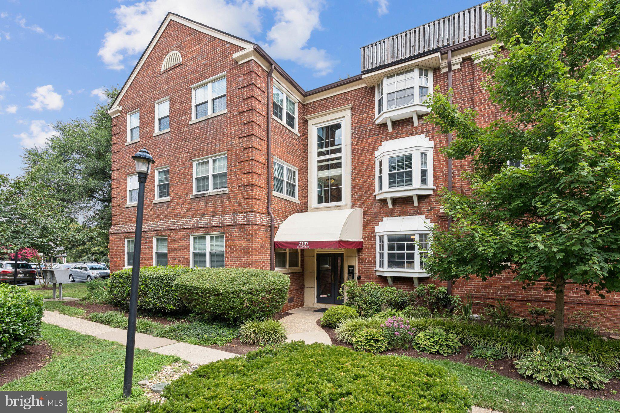 2107 North Scott Street, Unit 70 Arlington, VA 22209 - Photo 18 of 19 a front view of a house with yard and green space