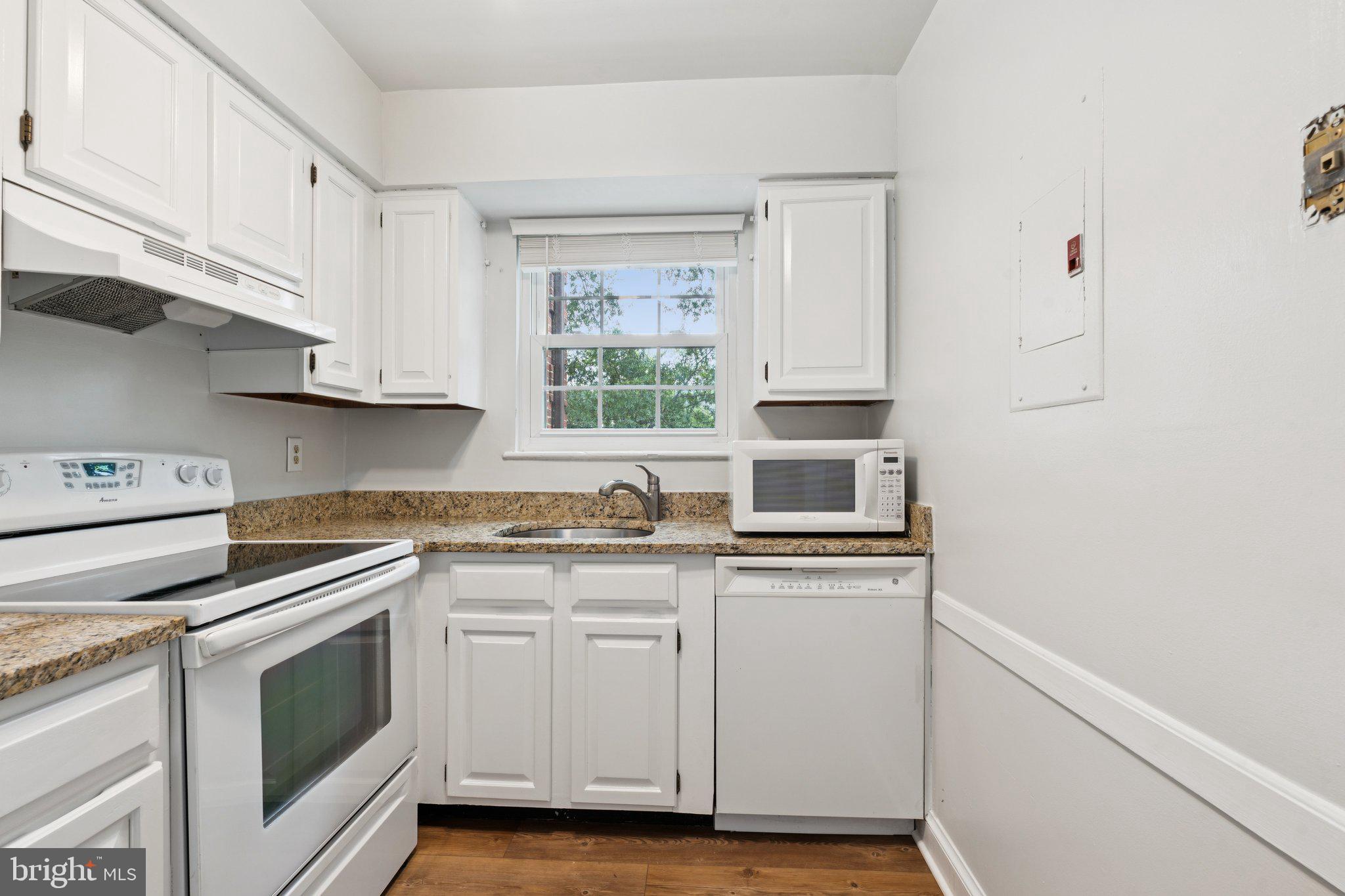 2107 North Scott Street, Unit 70 Arlington, VA 22209 - Photo 7 of 19 a kitchen with granite countertop white cabinets and white appliances