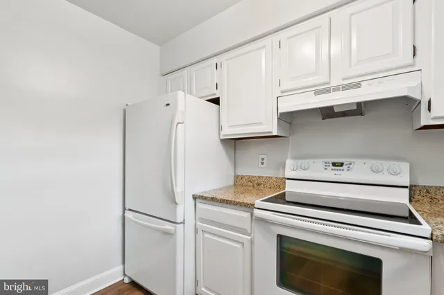 a kitchen with stainless steel appliances white cabinets and a refrigerator
