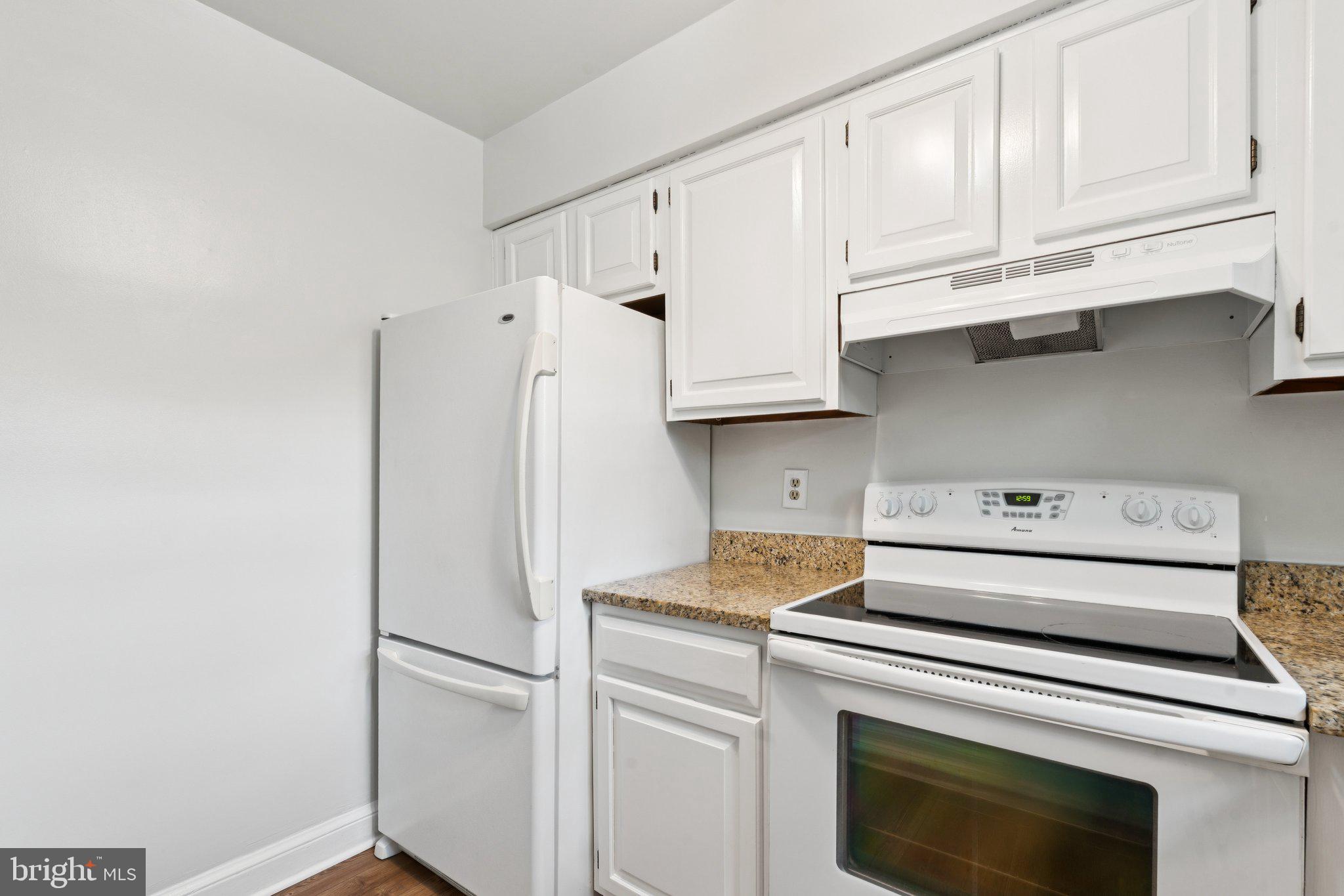 2107 North Scott Street, Unit 70 Arlington, VA 22209 - Photo 8 of 19 a kitchen with stainless steel appliances white cabinets and a refrigerator