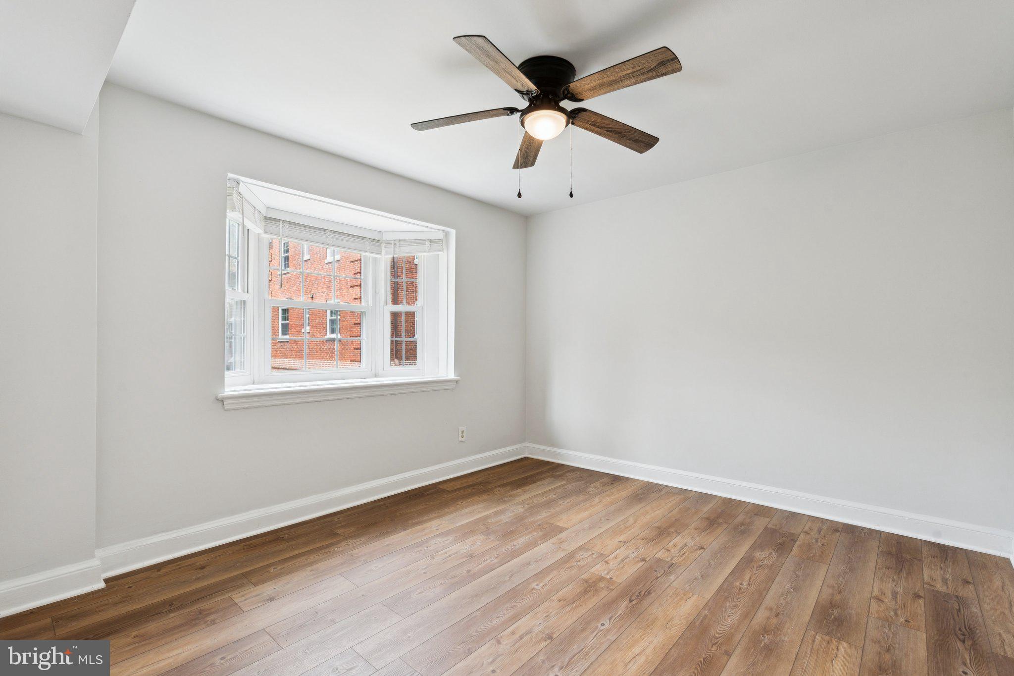 2107 North Scott Street, Unit 70 Arlington, VA 22209 - Photo 9 of 19 an empty room with wooden floor ceiling fan and windows