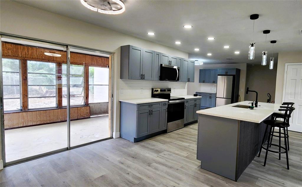 614 Huntington Street Brandon, FL 33511 - Photo 5 of 16 a kitchen with stainless steel appliances kitchen island granite countertop a sink counter space and a large window