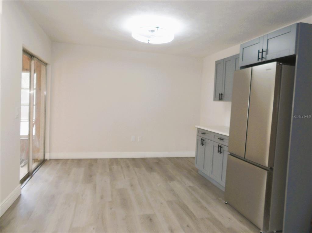 614 Huntington Street Brandon, FL 33511 - Photo 9 of 16 a view of a refrigerator in kitchen and wooden floor