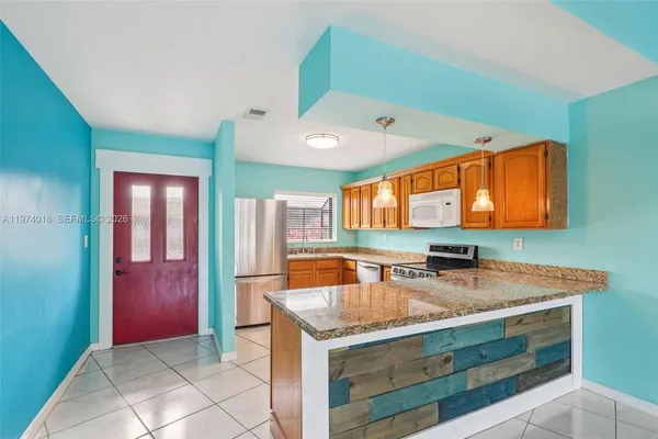 a kitchen with stainless steel appliances granite countertop a sink and a microwave oven