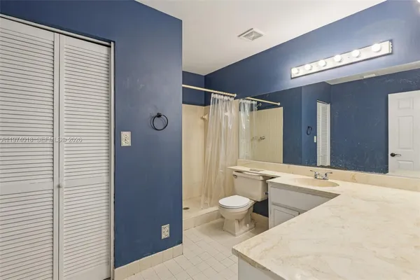 a bathroom with a bathtub shower sink vanity and toilet