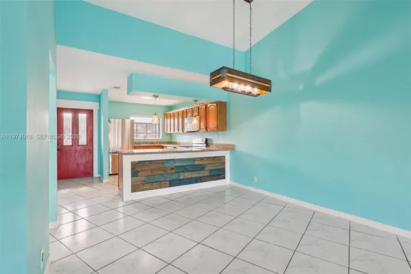 a kitchen with stainless steel appliances a stove and a chandelier