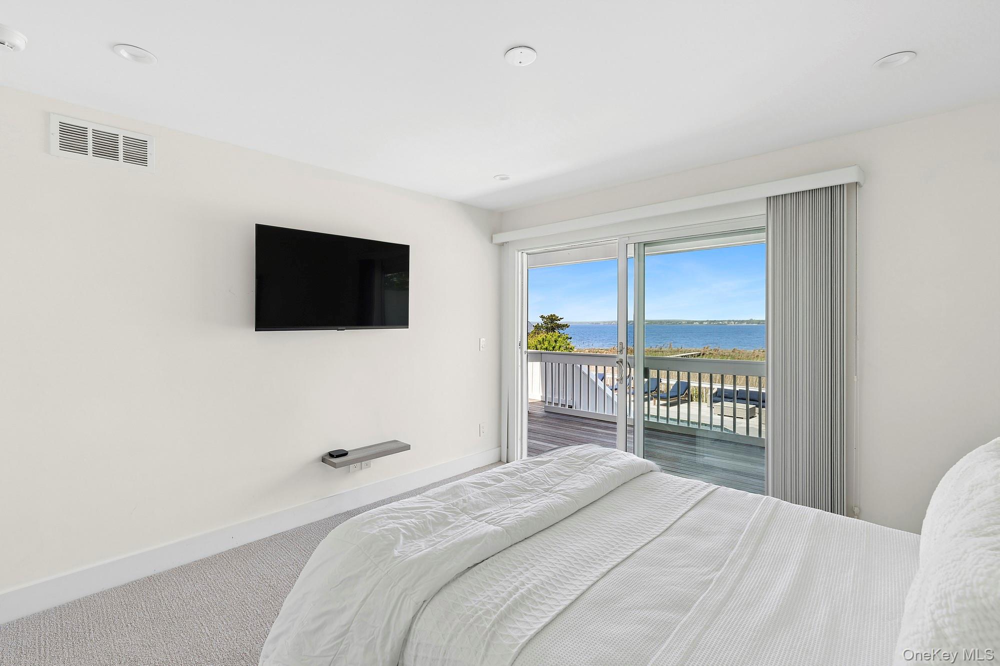 588 Dune Road Westhampton, NY 11978 - Photo 12 of 23 a bedroom with a bed and a flat screen tv