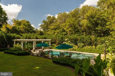 a kitchen with stainless steel appliances granite countertop a stove top oven a sink dishwasher and wooden cabinets with wooden floor