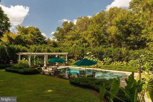 a kitchen with stainless steel appliances granite countertop a stove top oven a sink dishwasher and wooden cabinets with wooden floor