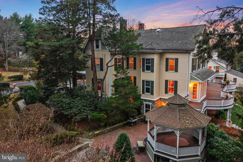 a view of a patio with table and chairs potted plants and large tree