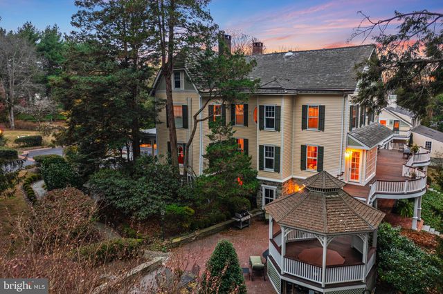 a view of a patio with table and chairs potted plants and large tree