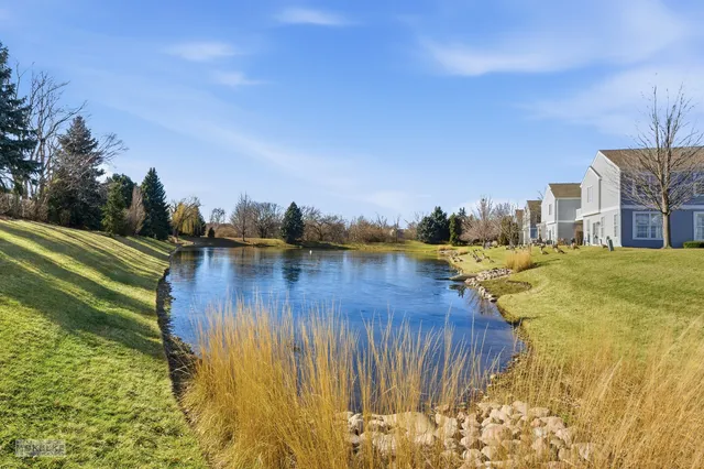 a kitchen with stainless steel appliances granite countertop a stove top oven a sink a dining table and chairs with wooden floor