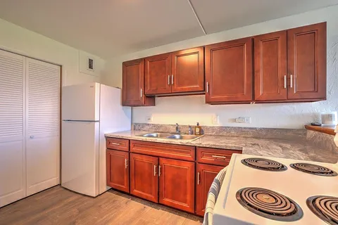 a kitchen with a refrigerator and a stove top oven
