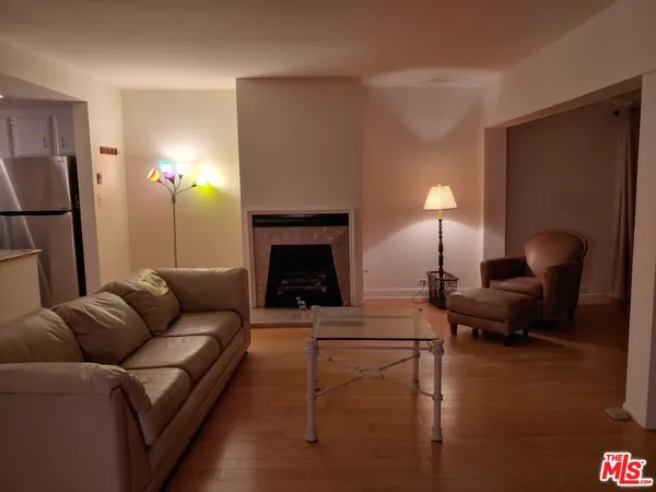 a living room with furniture and a view of kitchen