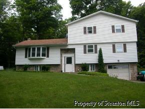 853 Spring Hill Road Sterling, PA 18463 - Photo 1 of 5 a front view of a house with a garden