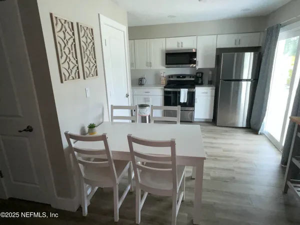 a kitchen with stainless steel appliances a stove a refrigerator and a dining table