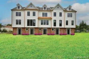 a view of a house with a big yard and large trees