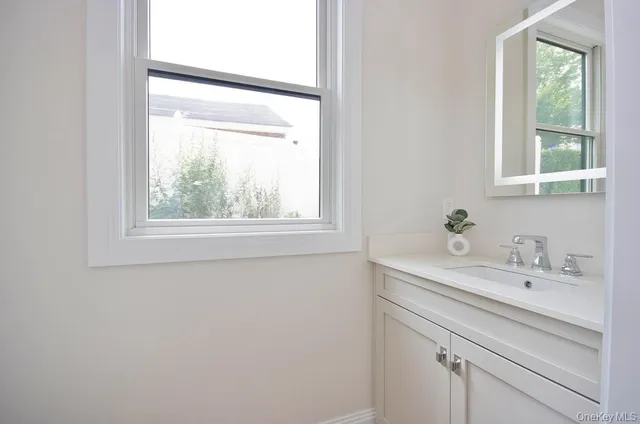 a bathroom with a sink a vanity and a window