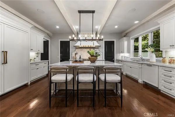 a kitchen with granite countertop a sink stainless steel appliances and cabinets