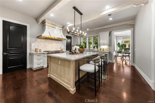 a hallway with wooden floor and chandelier