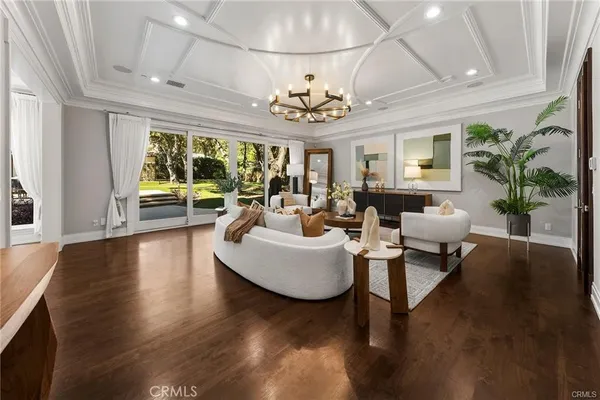 a view of hallway with walk in closet and wooden floor
